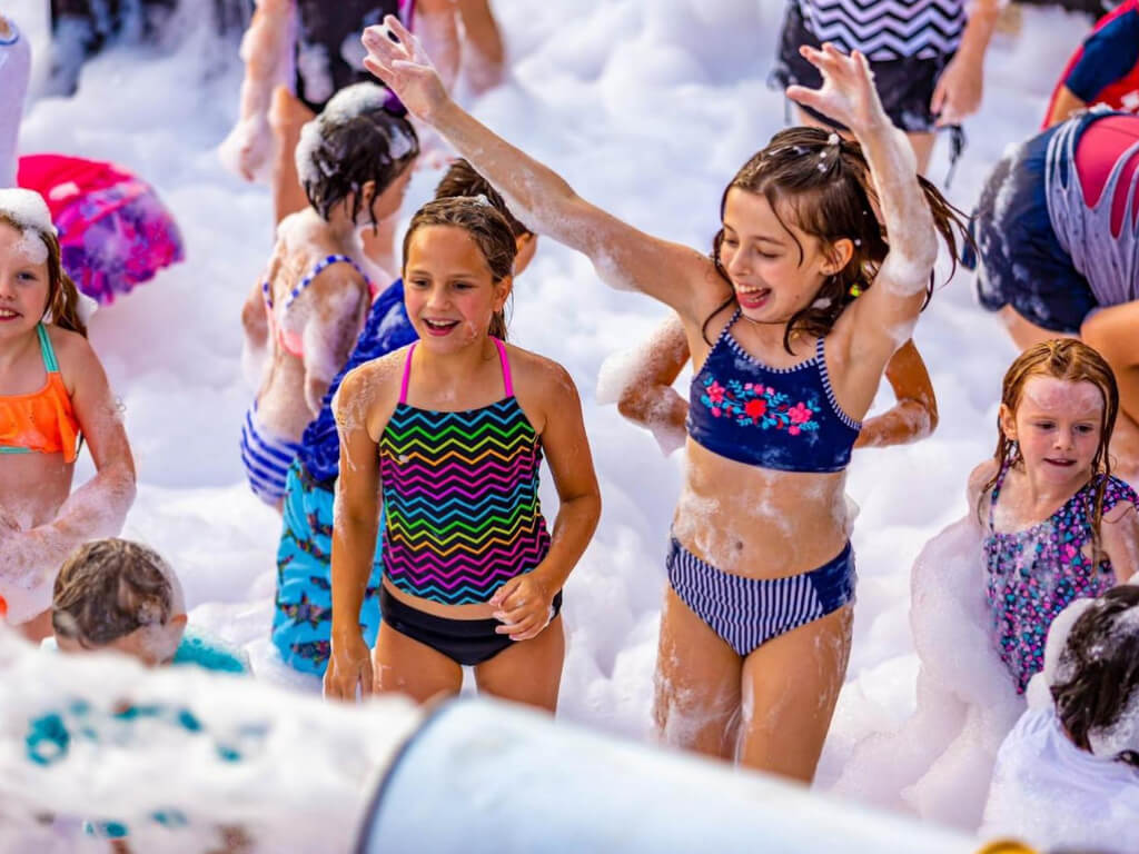 Kids dancing at an outdoor foam party